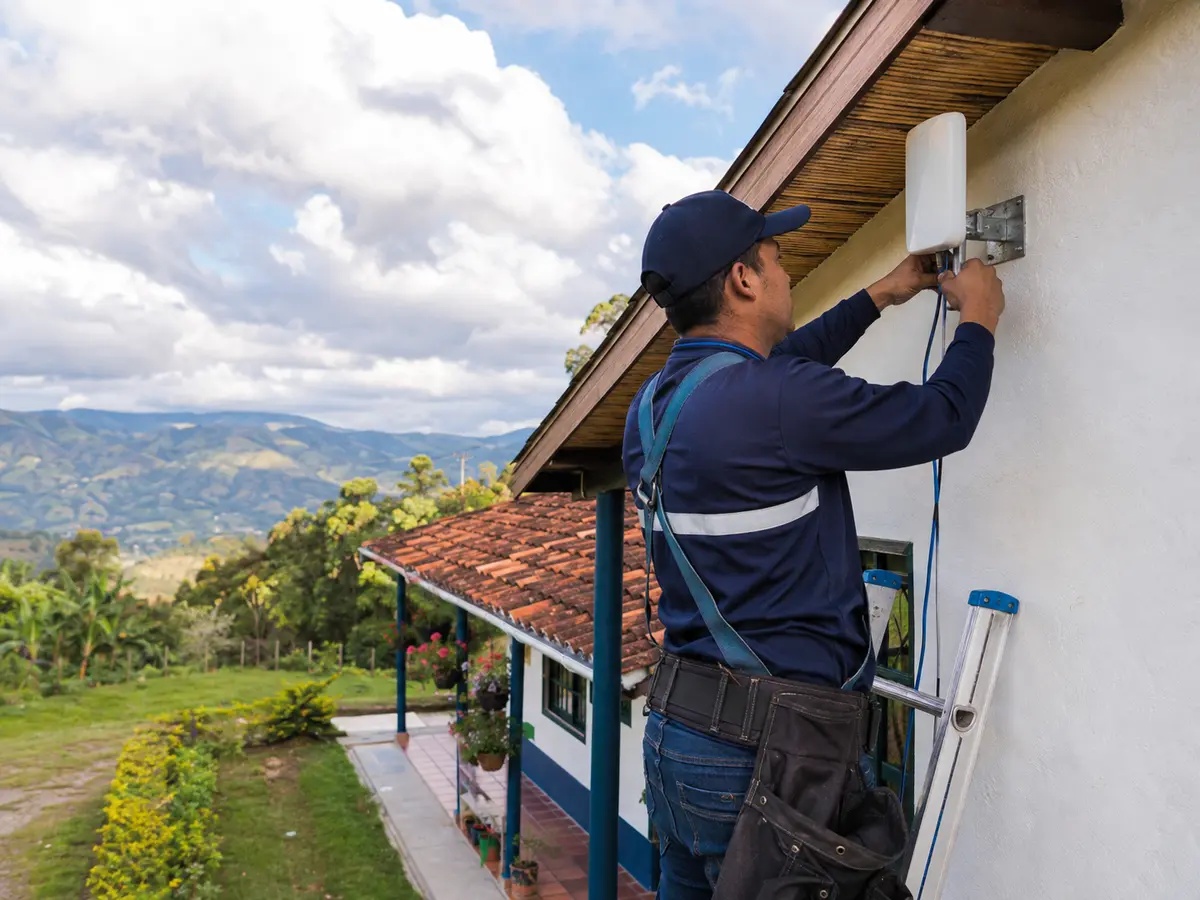 Técnico instalando una antena de internet en una finca